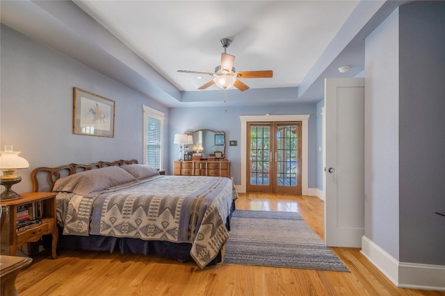903 E 14th St, Austin, TX 78702 - bedroom featuring a tray ceiling, light wood-style flooring, a ceiling fan, and access to exterior