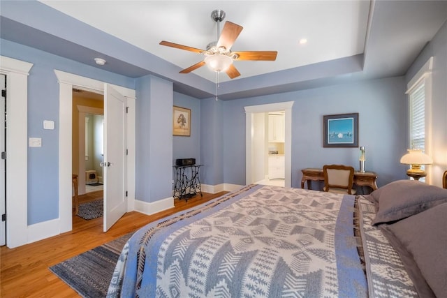 903 E 14th St, Austin, TX 78702 - bedroom featuring wood finished floors, a tray ceiling, a ceiling fan, and ensuite bath