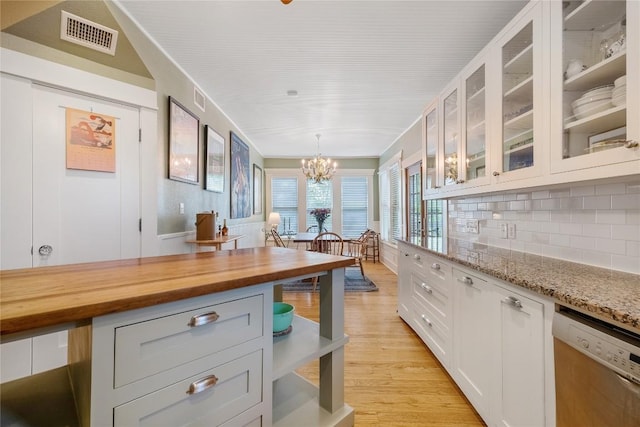 903 E 14th St, Austin, TX 78702 - kitchen featuring stainless steel dishwasher, wooden counters, white cabinetry, decorative backsplash, and a chandelier