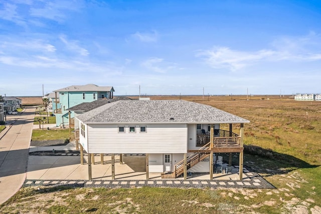 162 La Concha Blvd Unit 10, Port Aransas, TX 78373 - back of house featuring a patio, stairs, roof with shingles, and a deck
