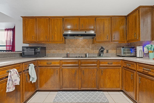1303 Creekview Dr, Round Rock, TX 78681 - kitchen with under cabinet range hood, black appliances, light tile patterned floors, and tasteful backsplash
