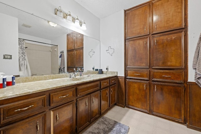 1303 Creekview Dr, Round Rock, TX 78681 - bathroom featuring vanity, a shower with curtain, a textured ceiling, and wainscoting