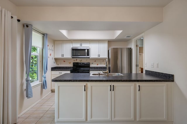 236 Lodestone Cir, Cedar Park, TX 78613 - kitchen with stainless steel appliances, a peninsula, dark countertops, white cabinets, and light tile patterned flooring