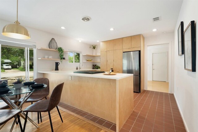 5507 Duval St Unit A, Austin, TX 78751 - kitchen with freestanding refrigerator, open shelves, light brown cabinetry, a peninsula, and light countertops