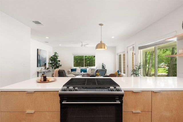 5507 Duval St Unit A, Austin, TX 78751 - kitchen featuring black gas range oven, modern cabinets, light countertops, open floor plan, and decorative light fixtures