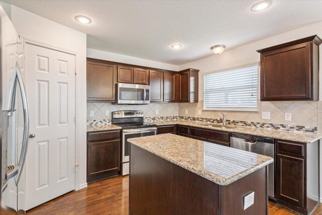 3211 Malmaison Rd, Killeen, TX 76542 - kitchen with stainless steel appliances, dark brown cabinetry, dark wood-type flooring, a kitchen island, and recessed lighting