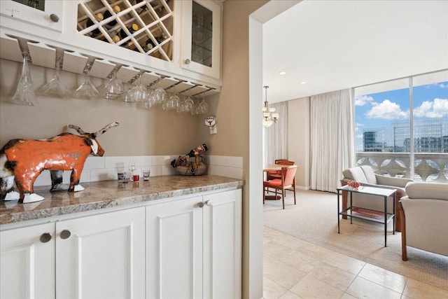 1801 Lavaca St Unit 9J, Austin, TX 78701 - bar area with light tile patterned floors, a chandelier, light carpet, backsplash, and a city view