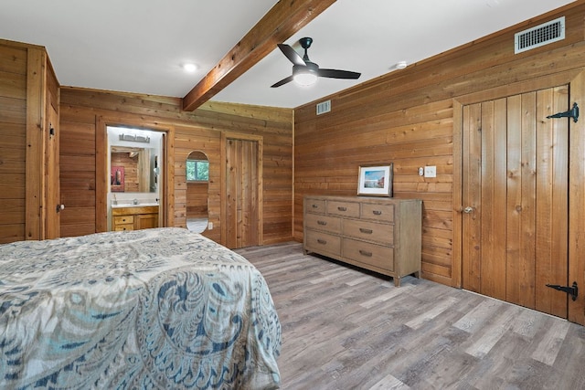 2609 Ellise Ave, Austin, TX 78757 - bedroom featuring beam ceiling, light wood-type flooring, wooden walls, ceiling fan, and ensuite bathroom