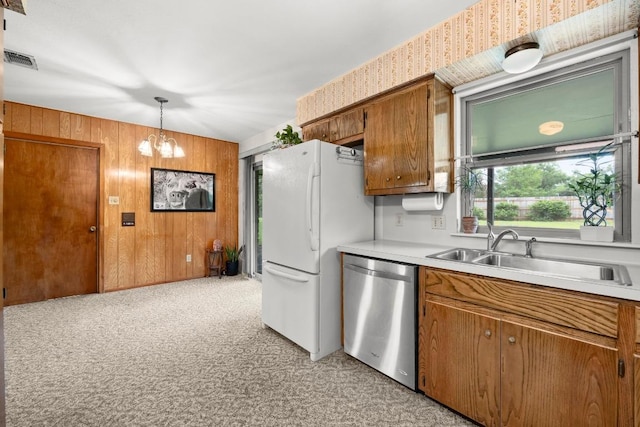 1411 Shenandoah Dr, Cedar Park, TX 78613 - kitchen featuring stainless steel dishwasher, brown cabinets, freestanding refrigerator, light countertops, and wooden walls