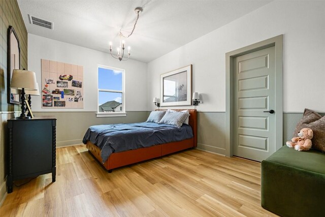 8405 Ambergill Ct, Austin, TX 78744 - bedroom with a chandelier and light wood-style flooring