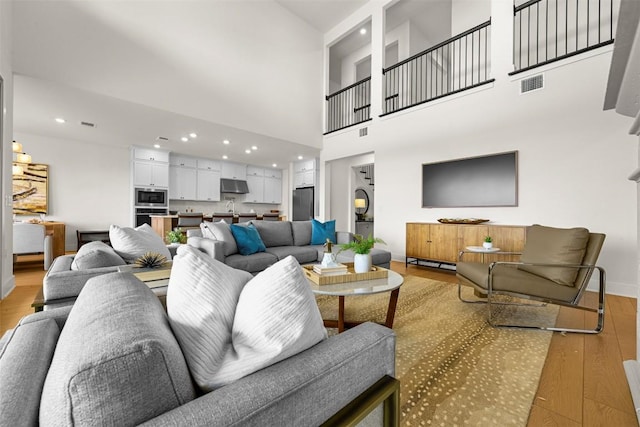 8405 Ambergill Ct, Austin, TX 78744 - living room with light wood-type flooring, recessed lighting, and a towering ceiling