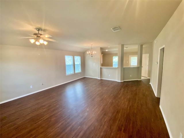 358 Spring, Kyle, TX 78640 - unfurnished living room featuring a chandelier, dark wood-style flooring, healthy amount of natural light, and a ceiling fan