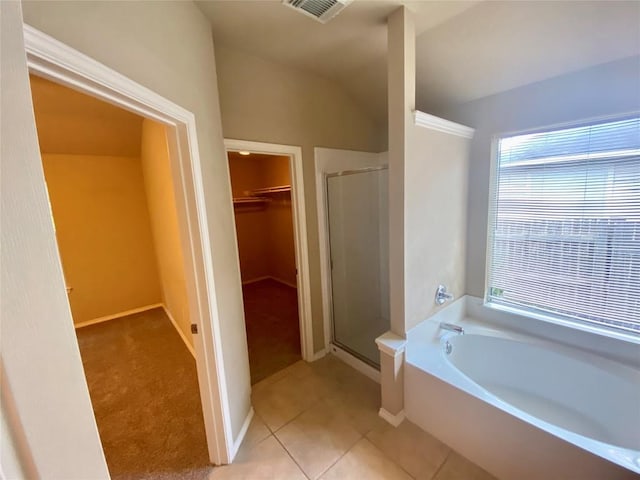 358 Spring, Kyle, TX 78640 - bathroom featuring a walk in closet, a shower stall, a garden tub, lofted ceiling, and tile patterned flooring