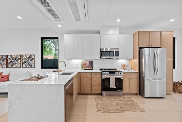 4428 Jinx Ave Unit 2, Austin, TX 78745 - kitchen featuring stainless steel appliances, a peninsula, recessed lighting, light wood finished floors, and light stone counters