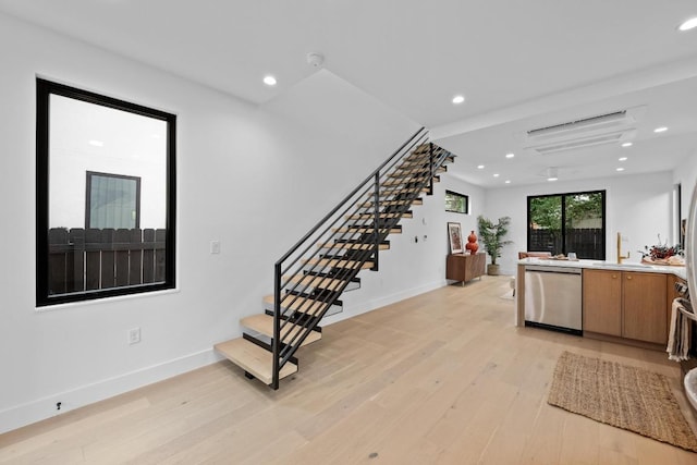 4428 Jinx Ave Unit 2, Austin, TX 78745 - kitchen with stainless steel dishwasher, light wood finished floors, recessed lighting, light countertops, and brown cabinetry
