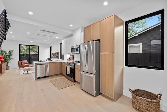 4428 Jinx Ave Unit 2, Austin, TX 78745 - kitchen featuring appliances with stainless steel finishes, light wood-style flooring, light brown cabinets, light countertops, and recessed lighting