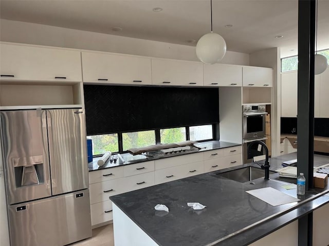 1603 Chelsea Ln Unit 1, Austin, TX 78704 - kitchen with appliances with stainless steel finishes, modern cabinets, white cabinets, decorative light fixtures, and decorative backsplash