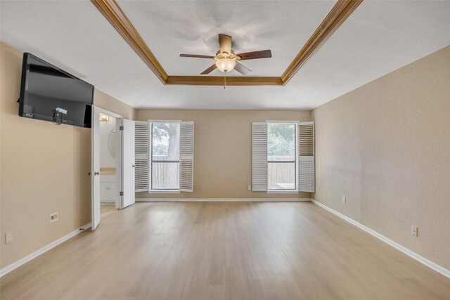 10007 Brantley Bnd, Austin, TX 78748 - unfurnished living room featuring a tray ceiling, light wood finished floors, ceiling fan, and crown molding
