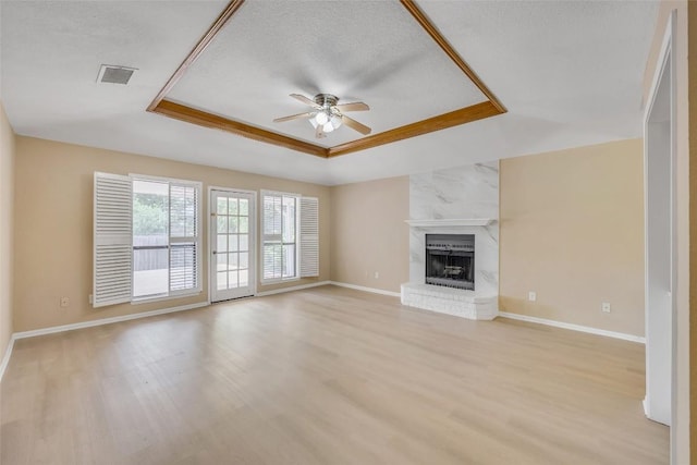 10007 Brantley Bnd, Austin, TX 78748 - unfurnished living room with a tray ceiling, a ceiling fan, light wood-style flooring, and a brick fireplace