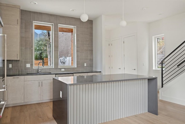 900 S 2nd St Unit 18, Austin, TX 78704 - kitchen with light wood-style flooring, a center island, modern cabinets, backsplash, and hanging light fixtures