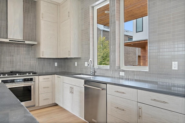 900 S 2nd St Unit 18, Austin, TX 78704 - kitchen with stainless steel appliances, wall chimney range hood, decorative backsplash, and light wood-style floors