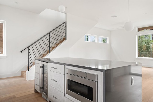 900 S 2nd St Unit 18, Austin, TX 78704 - stairs with wood finished floors, plenty of natural light, beverage cooler, and a ceiling fan