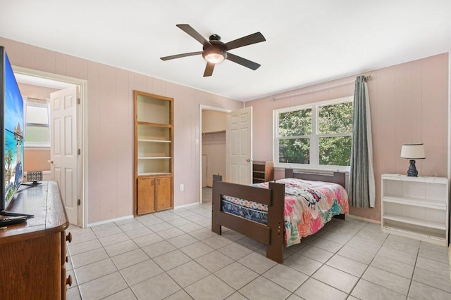 709 Harvey Ave, Burnet, TX 78611 - bedroom with light tile patterned floors, ceiling fan, and a spacious closet