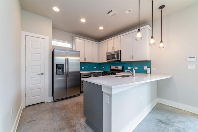 1904 Cleese Dr Unit 172, Austin, TX 78741 - kitchen with appliances with stainless steel finishes, a peninsula, white cabinetry, backsplash, and concrete flooring