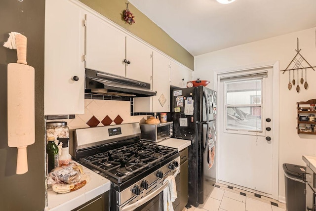 3309 Whitepine Dr, Austin, TX 78757 - kitchen featuring under cabinet range hood, stainless steel appliances, white cabinets, tasteful backsplash, and tile counters