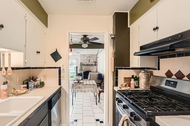 3309 Whitepine Dr, Austin, TX 78757 - kitchen with appliances with stainless steel finishes, exhaust hood, a ceiling fan, a fireplace, and white cabinets