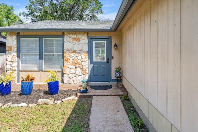 7801 Elderberry Dr, Austin, TX 78745 - doorway to property featuring stone siding and roof with shingles