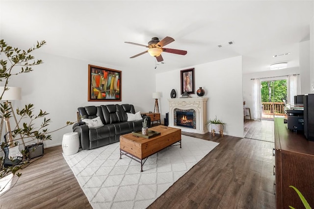 7801 Elderberry Dr, Austin, TX 78745 - living room featuring wood finished floors, a ceiling fan, and a warm lit fireplace