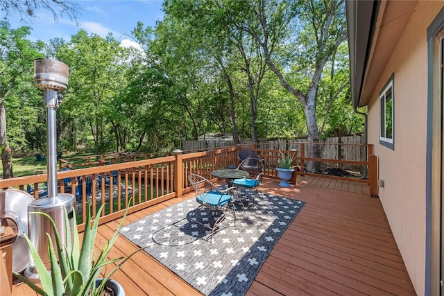 7801 Elderberry Dr, Austin, TX 78745 - wooden terrace with a fenced backyard, outdoor dining area, and view of scattered trees