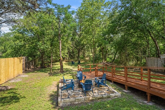 7801 Elderberry Dr, Austin, TX 78745 - fenced backyard with a fire pit and a wooden deck