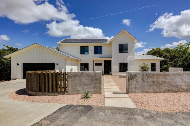 8009 Golden Oaks Ln, Austin, TX 78737 - modern farmhouse featuring board and batten siding, a fenced front yard, an attached garage, solar panels, and driveway