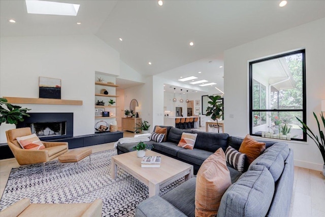 8009 Golden Oaks Ln, Austin, TX 78737 - living room with a skylight, a tiled fireplace, recessed lighting, light wood-style flooring, and built in features