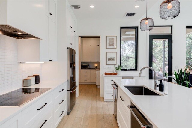 8009 Golden Oaks Ln, Austin, TX 78737 - kitchen featuring appliances with stainless steel finishes, wall chimney range hood, light countertops, and recessed lighting