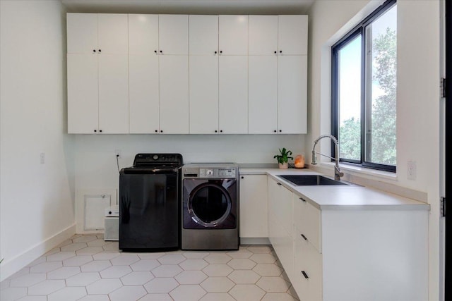 8009 Golden Oaks Ln, Austin, TX 78737 - laundry area featuring cabinet space, plenty of natural light, washer and clothes dryer, and light tile patterned floors