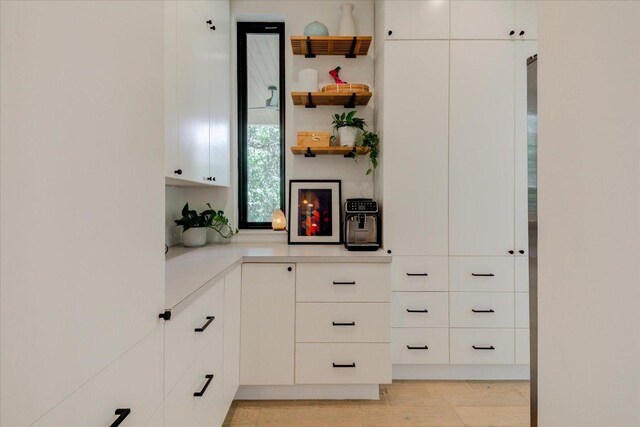 8009 Golden Oaks Ln, Austin, TX 78737 - kitchen with light countertops, open shelves, white cabinetry, and light wood finished floors