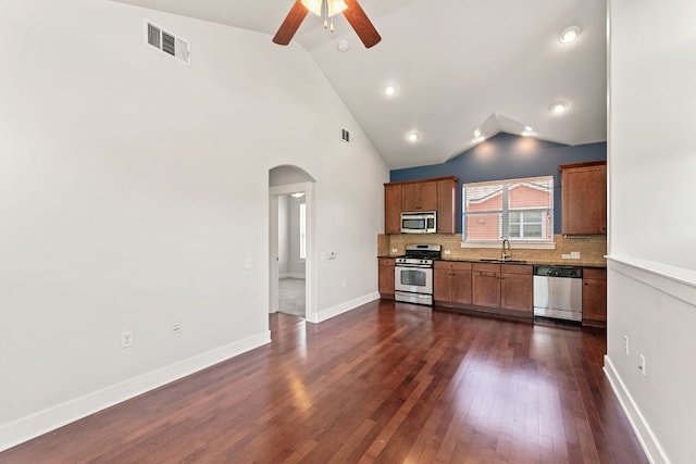 1601 Miriam Ave Unit 216, Austin, TX 78702 - kitchen with stainless steel appliances, arched walkways, lofted ceiling, ceiling fan, and tasteful backsplash