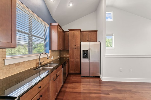 1601 Miriam Ave Unit 216, Austin, TX 78702 - kitchen with appliances with stainless steel finishes, vaulted ceiling, dark wood-style flooring, dark stone countertops, and tasteful backsplash
