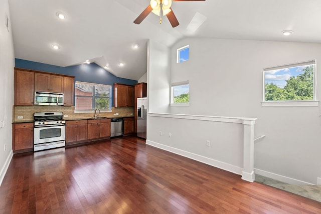 1601 Miriam Ave Unit 216, Austin, TX 78702 - kitchen with stainless steel appliances, vaulted ceiling, dark wood-type flooring, a ceiling fan, and tasteful backsplash
