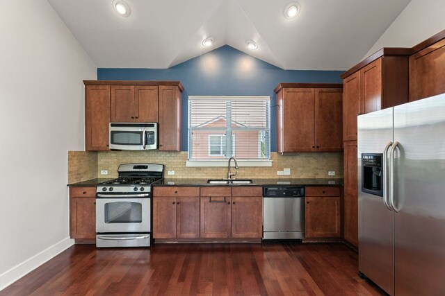 1601 Miriam Ave Unit 216, Austin, TX 78702 - kitchen with appliances with stainless steel finishes, dark wood-style floors, vaulted ceiling, brown cabinetry, and tasteful backsplash