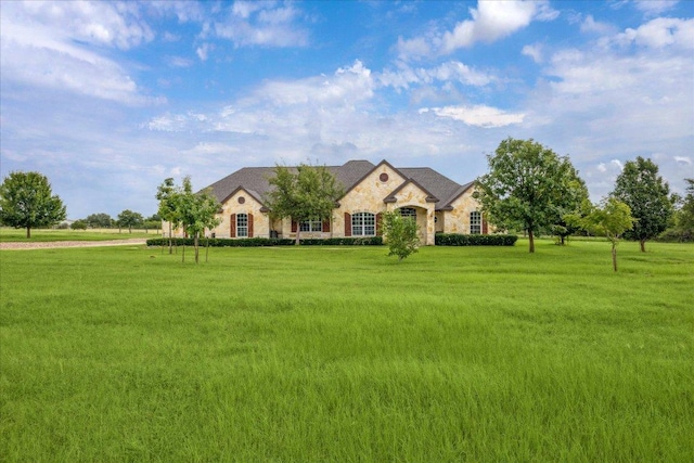 144 Escondido Dr, Del Valle, TX 78617 - french country style house featuring stone siding and a front lawn