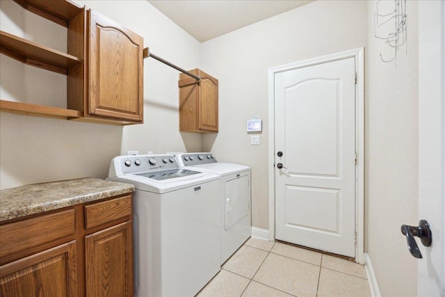 144 Escondido Dr, Del Valle, TX 78617 - laundry room featuring separate washer and dryer, cabinet space, and light tile patterned floors