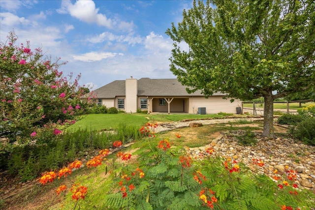 144 Escondido Dr, Del Valle, TX 78617 - rear view of property featuring a chimney and a yard