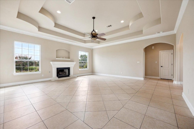 144 Escondido Dr, Del Valle, TX 78617 - unfurnished living room with a ceiling fan, a raised ceiling, light tile patterned floors, arched walkways, and crown molding