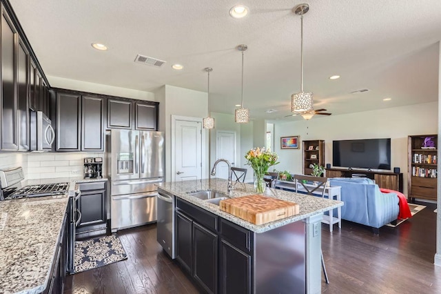 3025 Lions Tail St, Austin, TX 78728 - kitchen featuring stainless steel appliances, ceiling fan, light stone countertops, dark wood-type flooring, and backsplash