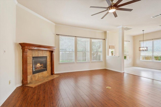 102 Country View Way, Cedar Park, TX 78613 - unfurnished living room with a tile fireplace, a ceiling fan, wood finished floors, crown molding, and a chandelier