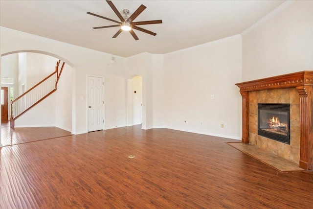 102 Country View Way, Cedar Park, TX 78613 - unfurnished living room featuring a ceiling fan, arched walkways, ornamental molding, a tiled fireplace, and wood finished floors
